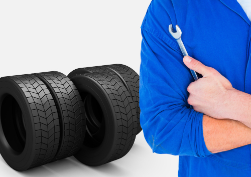 Person holding wrench in front of tires