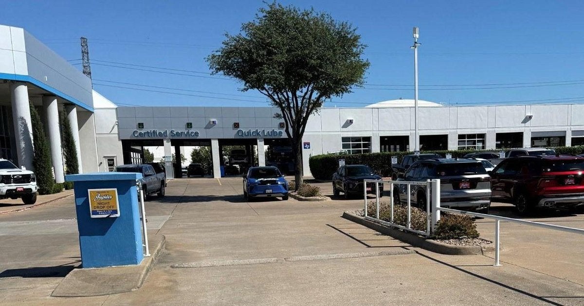 Night drop-off box at the entrance to Jupiter Chevrolet in Garland, TX, with the Certified Service building behind it