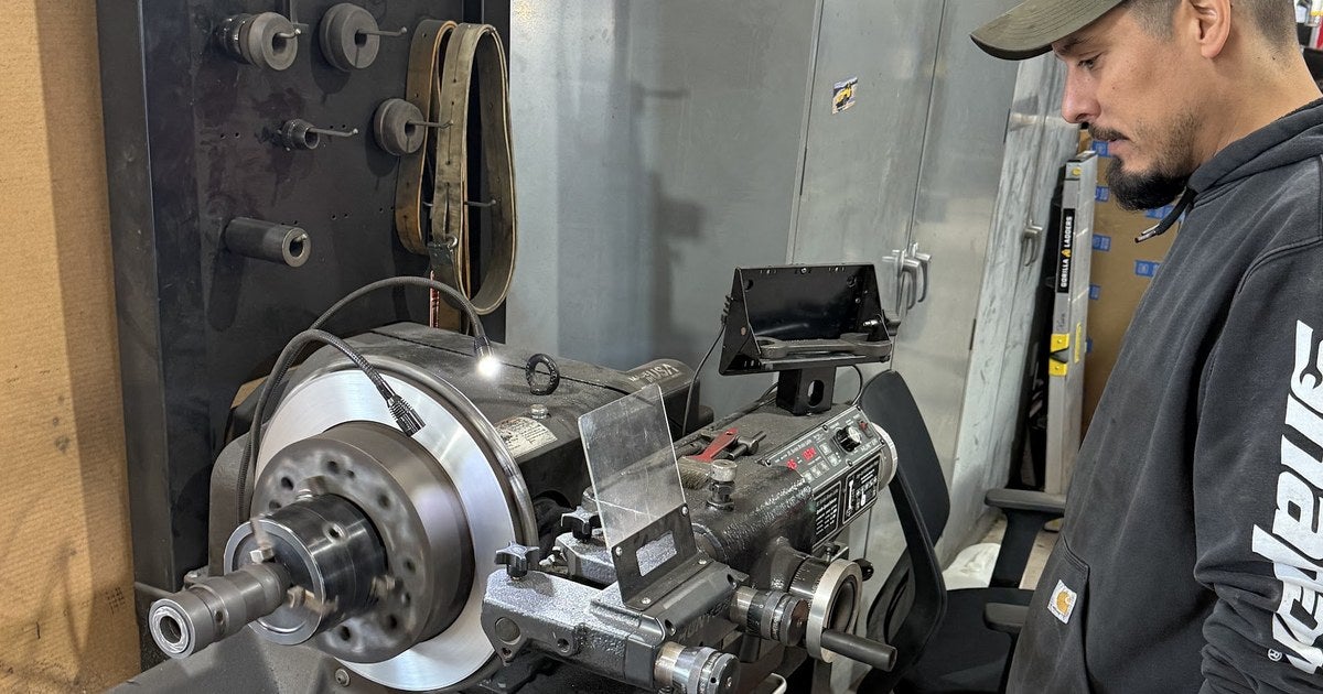 Technician resurfacing a brake rotor on the lathe in the service shop at Jupiter Chevrolet in Garland, TX