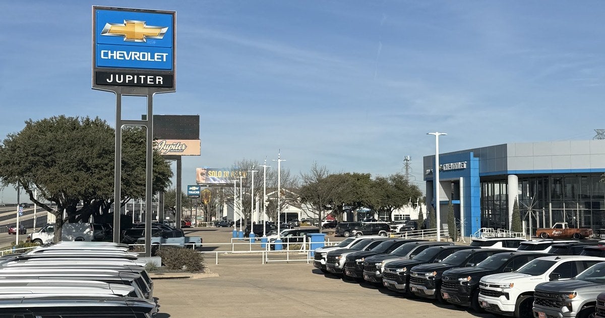 Jupiter Chevrolet dealership lot in Garland, TX with the Chevrolet pylon sign and rows of new Silverado pickups