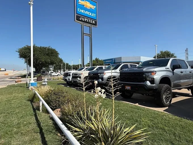 Chevrolet Silverado trucks lined up under the Jupiter Chevrolet sign on the lot in Garland, Texas